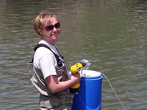 Julie Kelso uses a pump MacGyvered onto a battery powered drill to filter Utah Lake into a highly scientific sterile 5 gallon cooler. This water will be used in incubations along the Jordan River